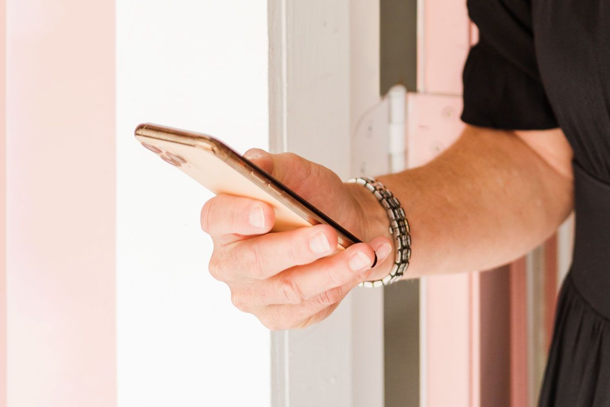 A close-up image of a hand holding a phone