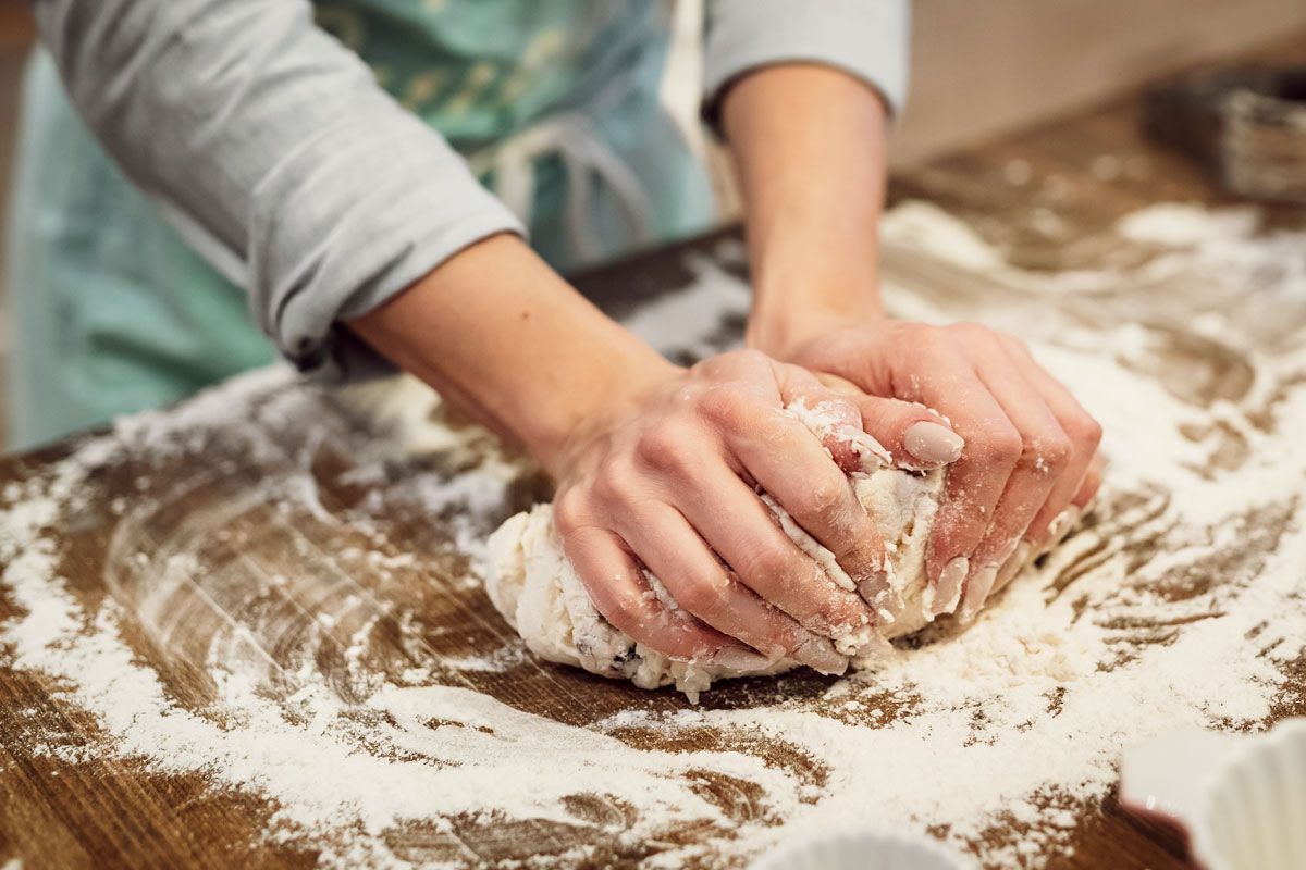 An image of a person kneading dough on a floured surface