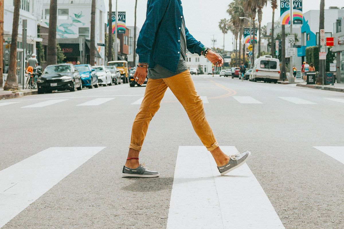 An image of a man walking across the street