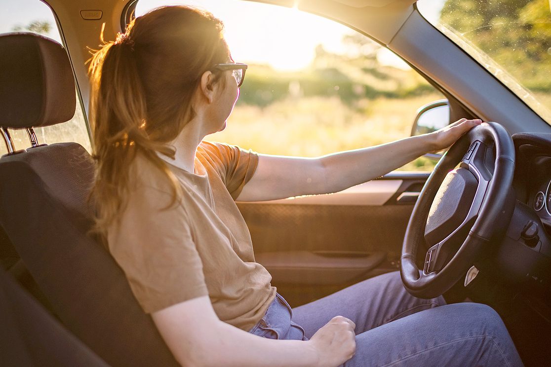 An image of a woman sitting in the driver's seat of a car