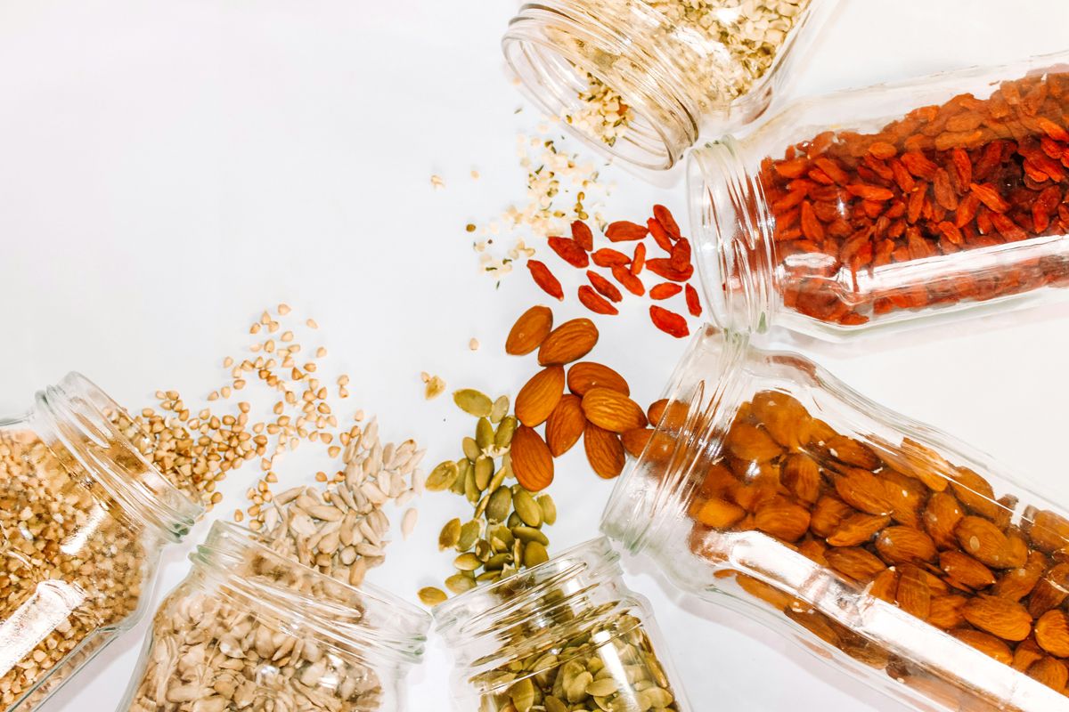 An image of jars of nuts an seeds spilling out