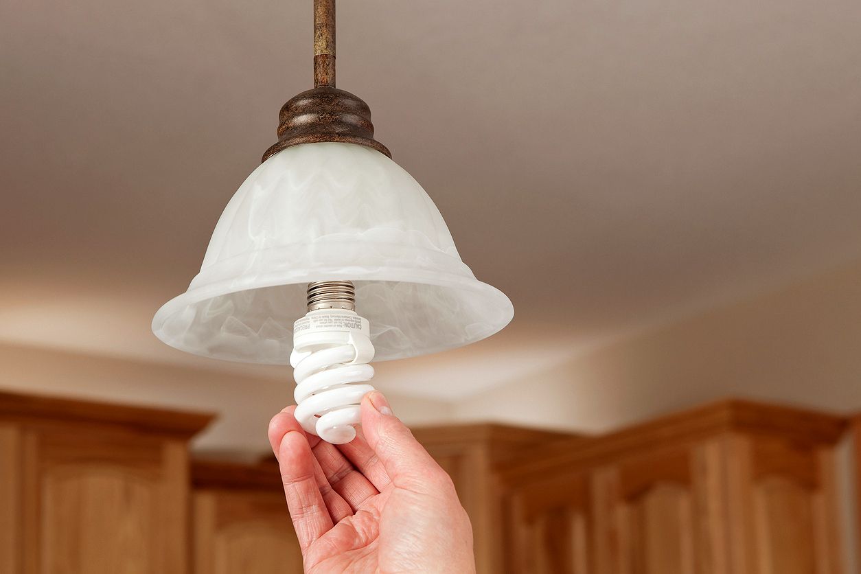 An image of a hand screwing a lightbulb