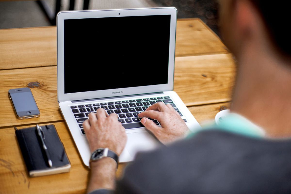 An image of a man typing on a laptop