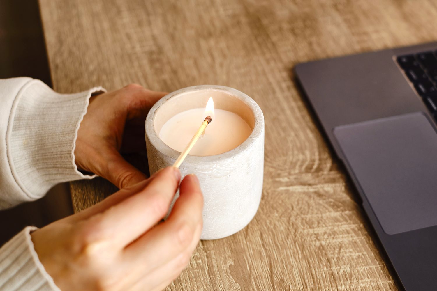 An image of a person lighting a candle with a match
