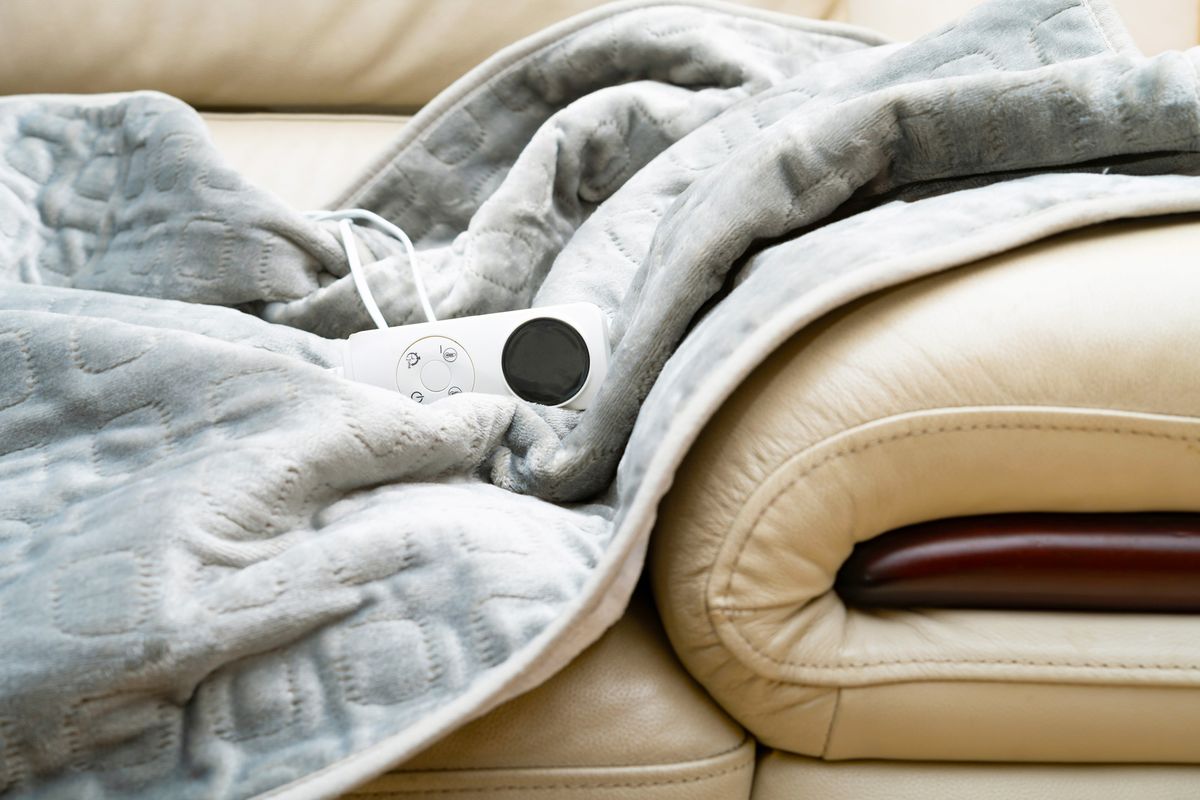 Electric blanket with controller on a sofa