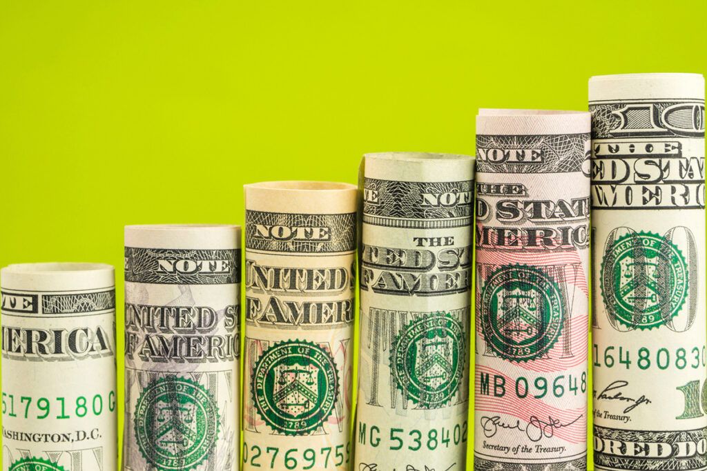 Rolled up money in front of a green background