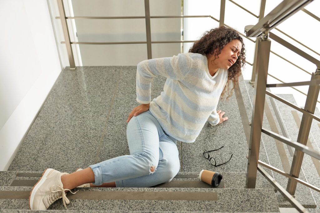 Woman who fell down the stairs holding her back