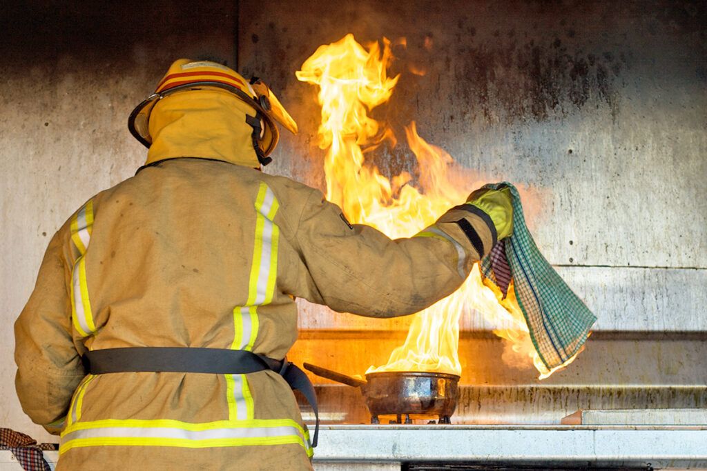 Firefighter in front of pan on fire