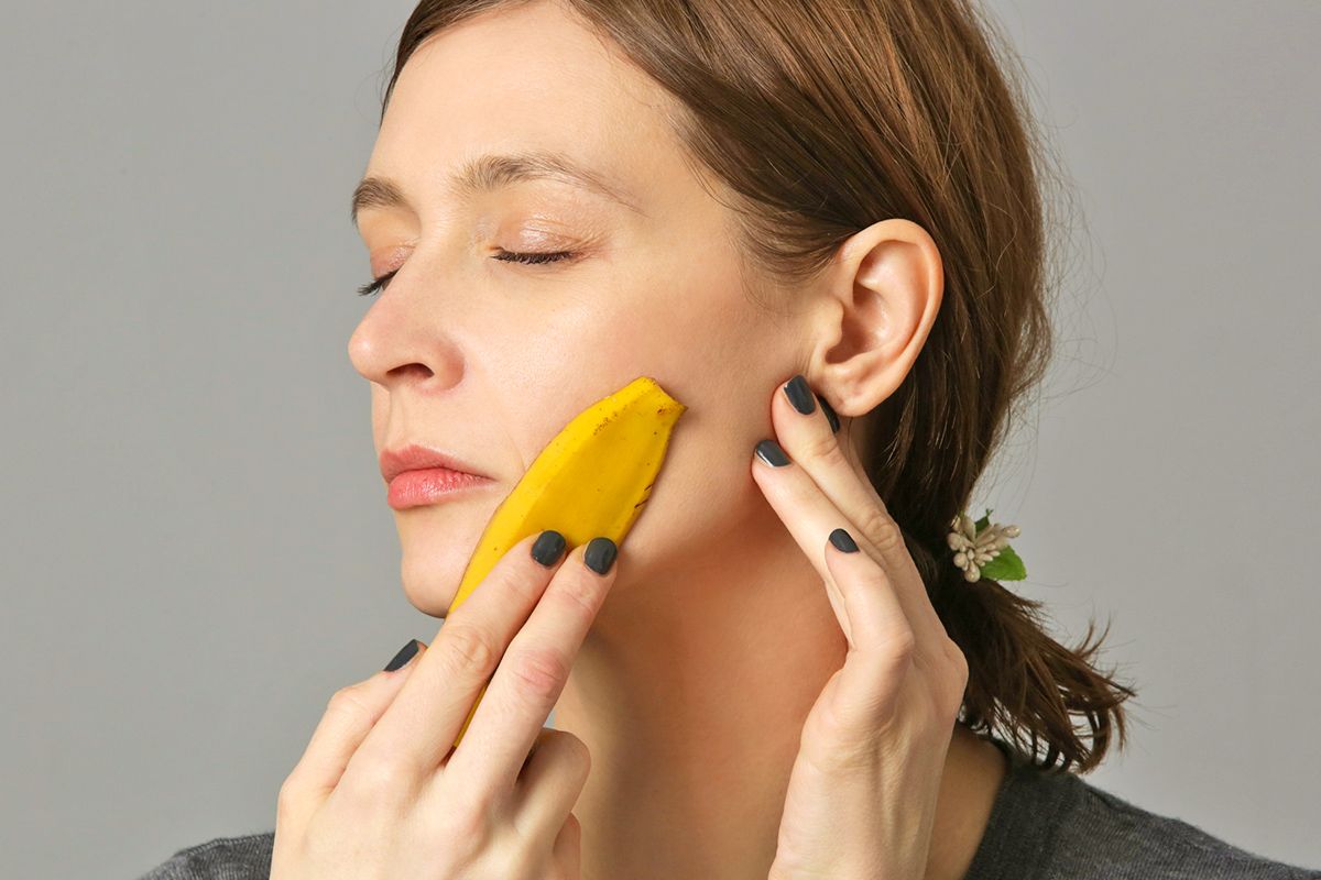 Woman running banana peel on face