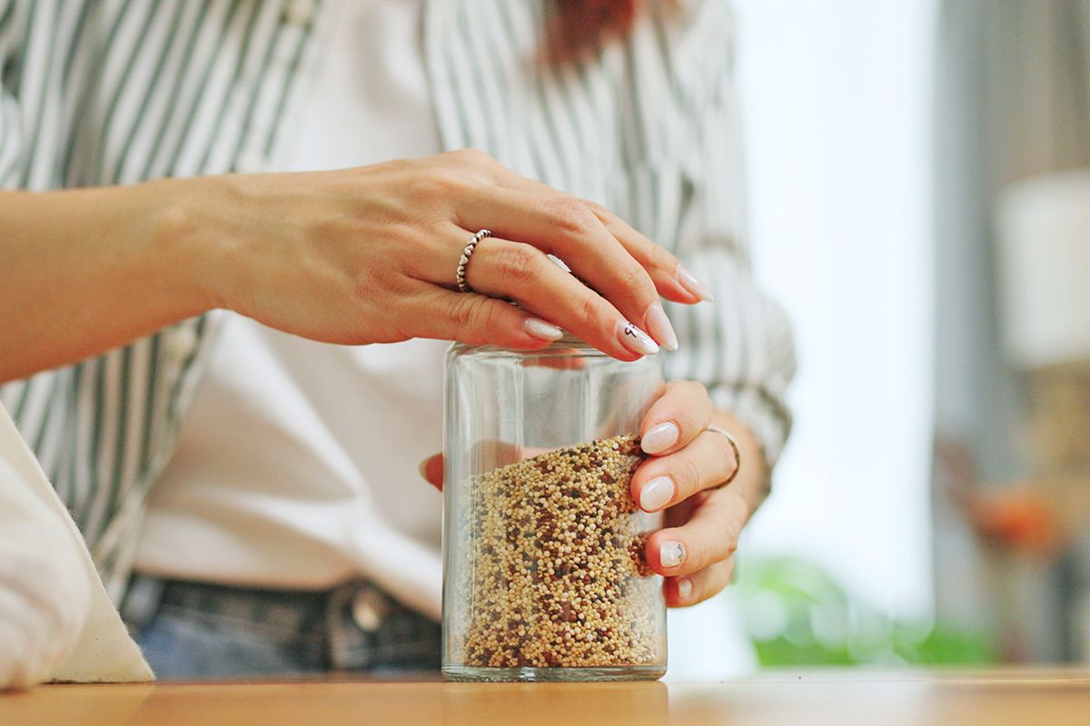 Person putting lid on a jar of grains