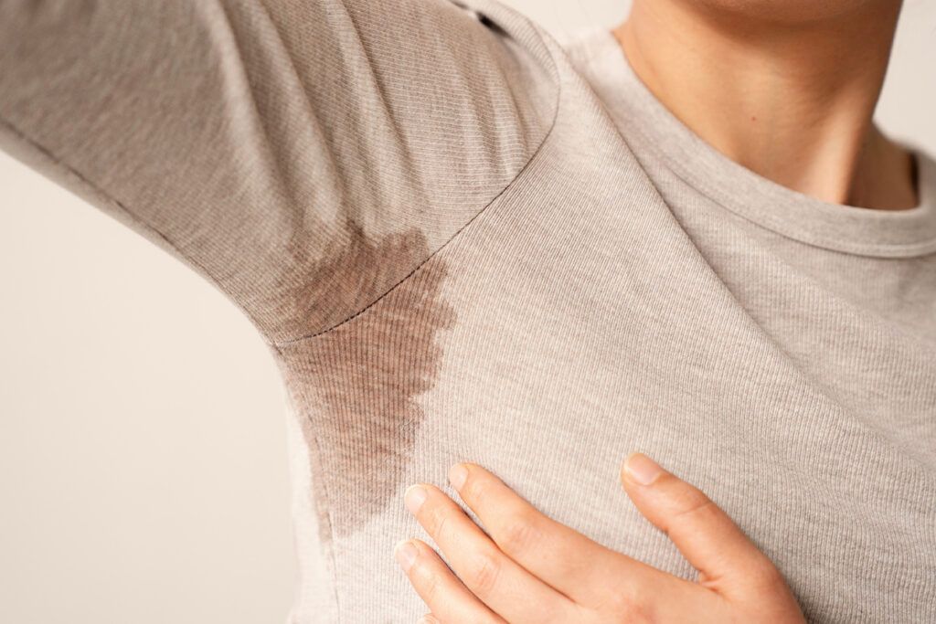Person with sweat stain in the armpit of their shirt