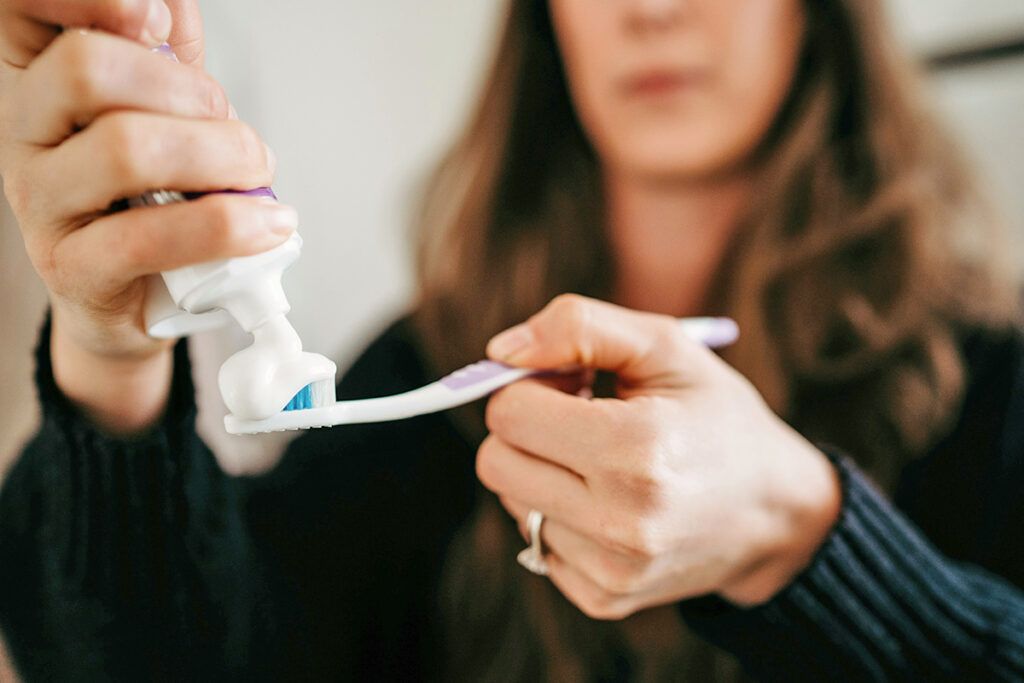 Putting toothpaste on a toothbrush