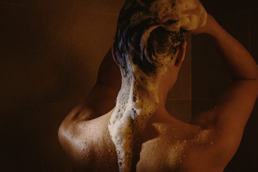 Person shampooing hair at night