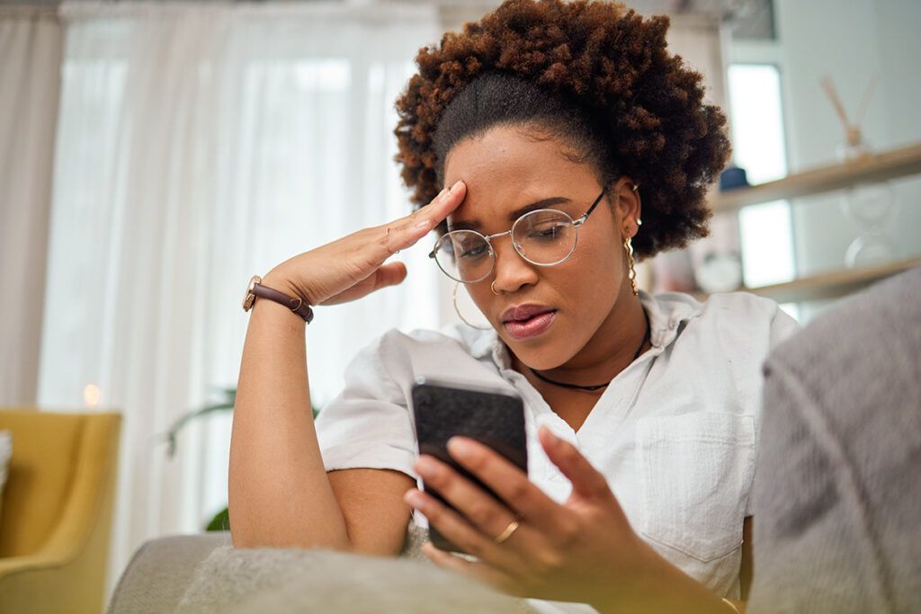 Woman looking down at phone upset