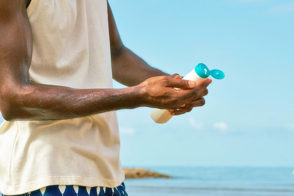 Man putting sunscreen in hand