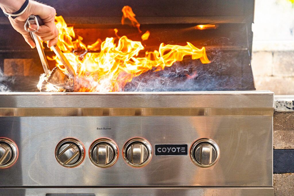Person cooking on grill with fire