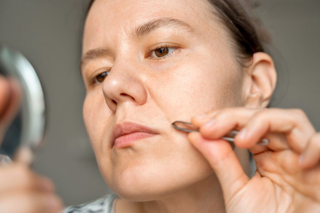 Woman plucking face hair