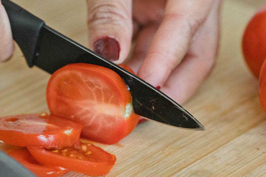 Knife cutting tomato