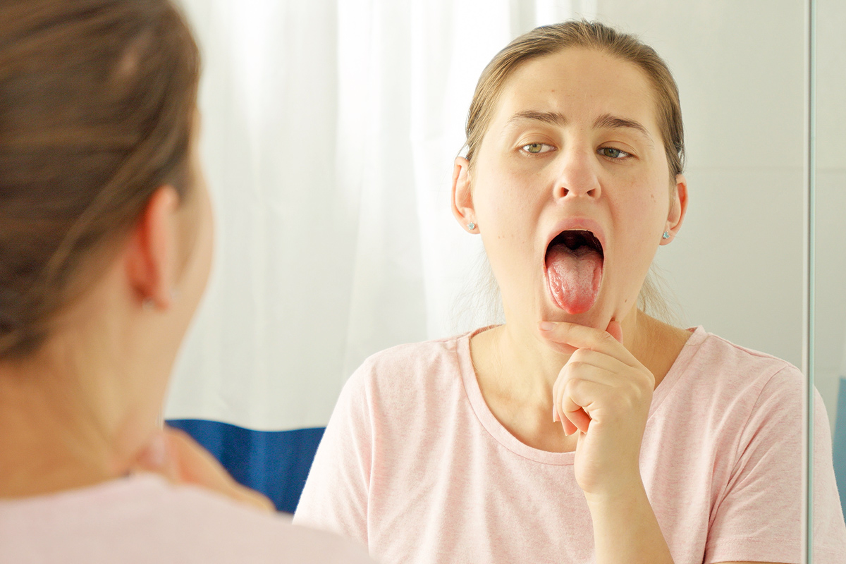 Woman scraping tongue