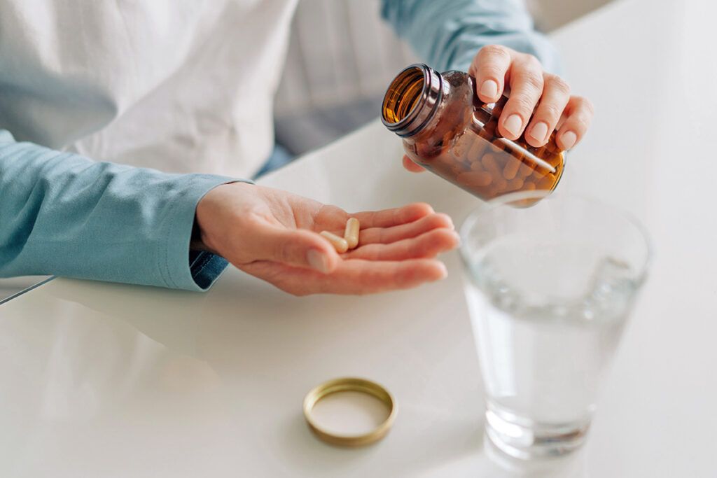 Person holding bottle with pills in hand