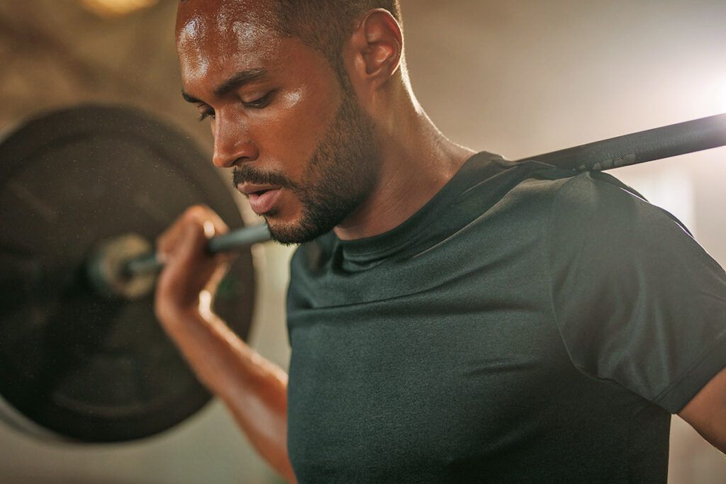 Man lifting weights and sweating