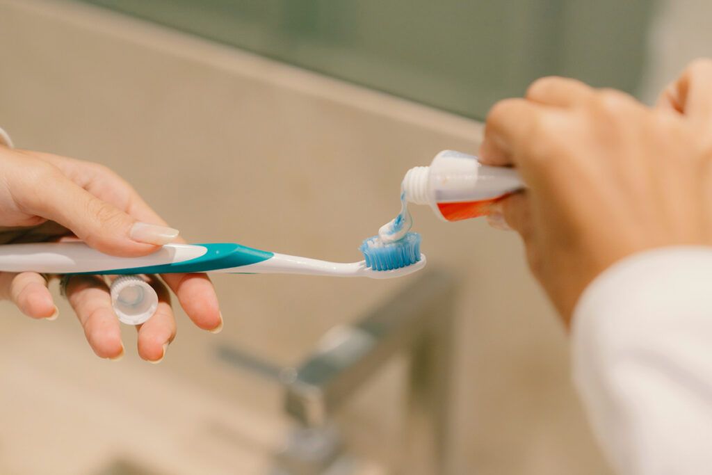 Putting toothpaste on toothbrush