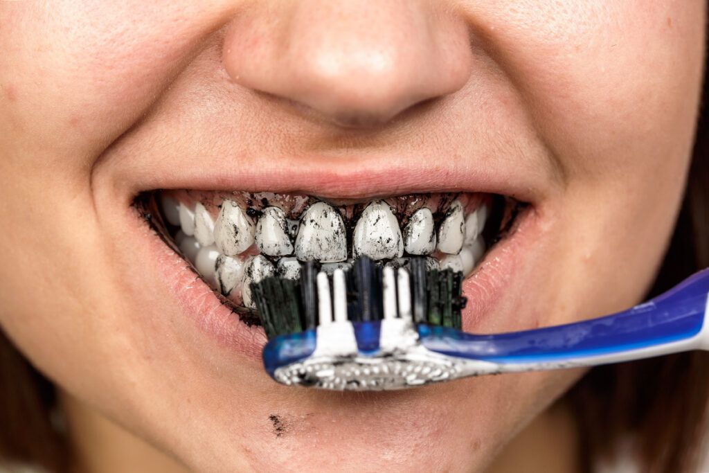 Brushing teeth with charcoal toothpaste