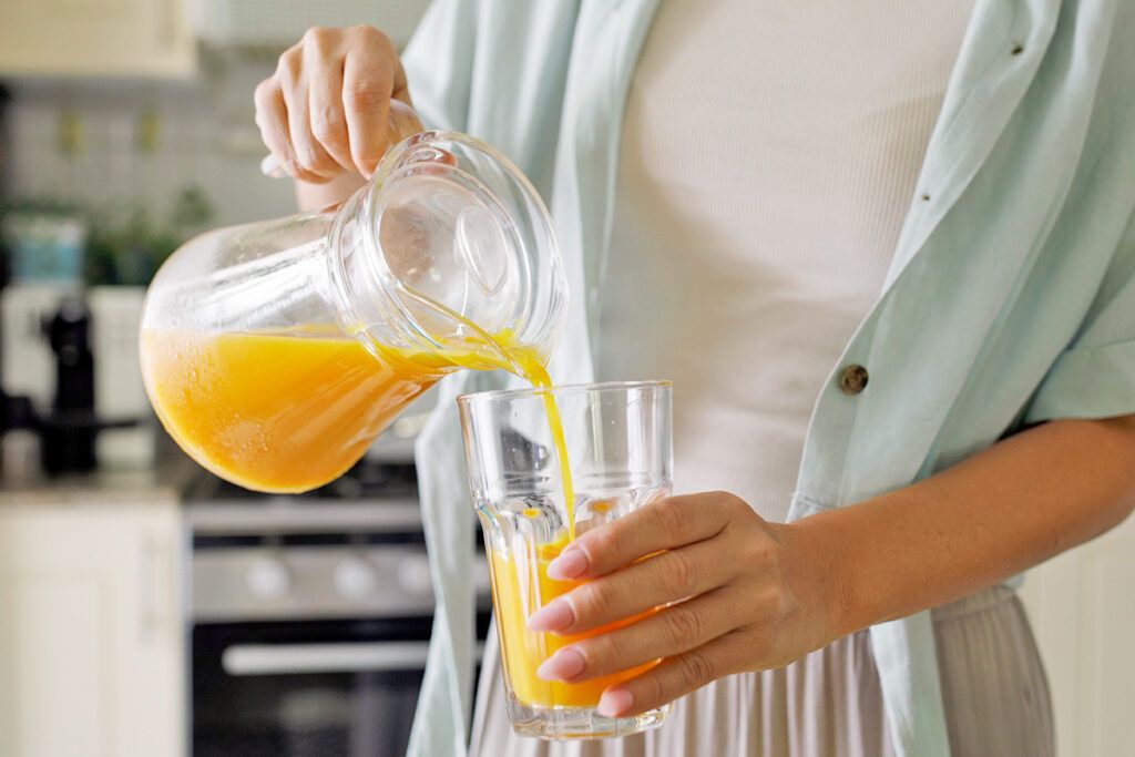 Woman pouring orange juice