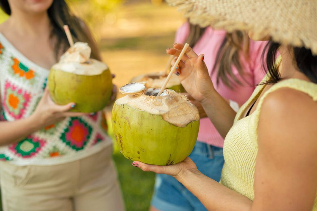 Women drinking out of coconuts