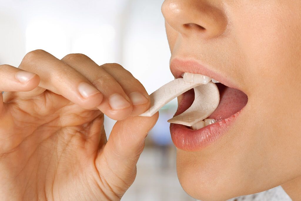 Woman putting gum in mouth
