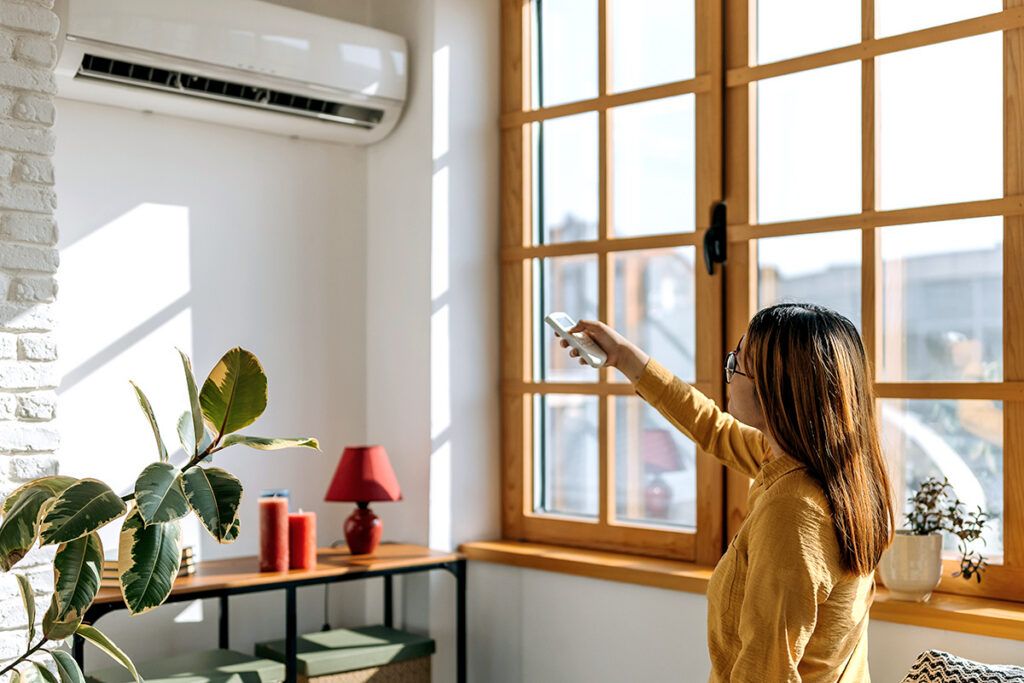 Woman using remote with AC unit