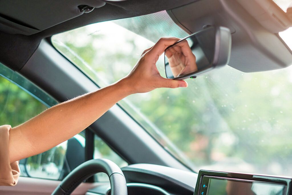 Hand adjusting rearview mirror