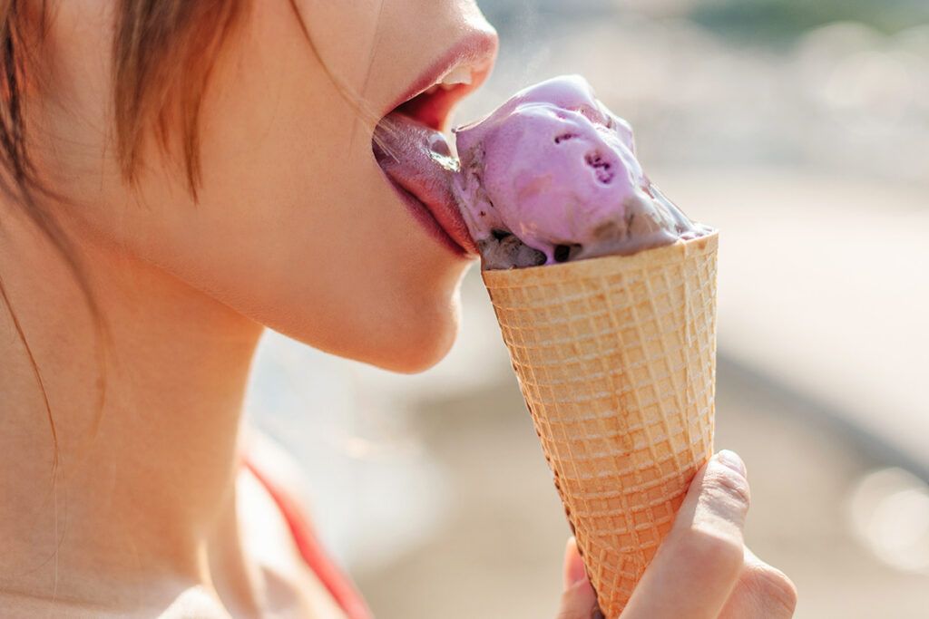 Woman licking ice cream cone