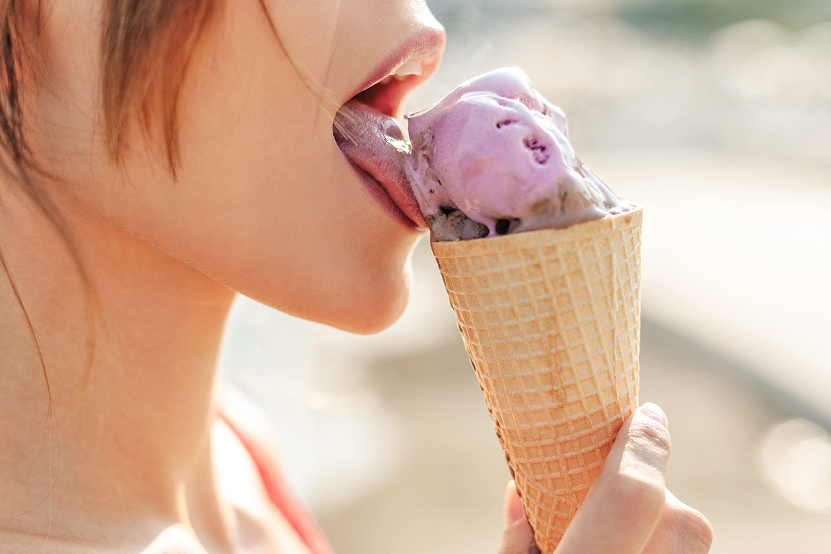 Woman licking ice cream cone
