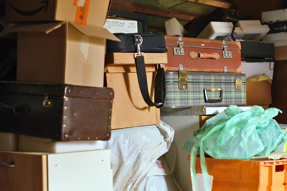 Stacks of luggage, boxes, and bags in a basement