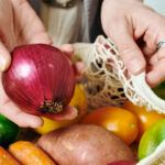 Hand holding a red onion
