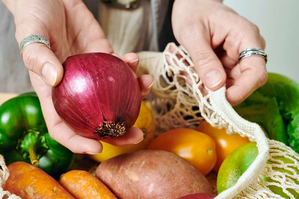 Hand holding a red onion