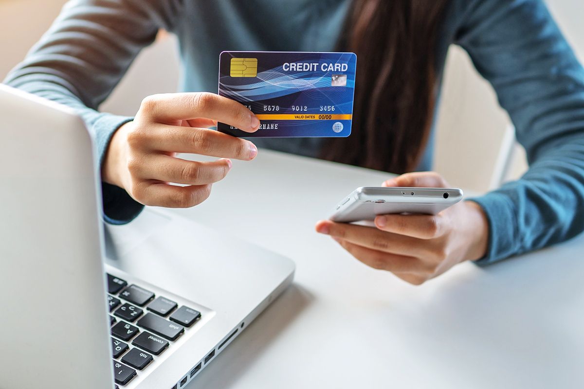Perosn holding up a credit card