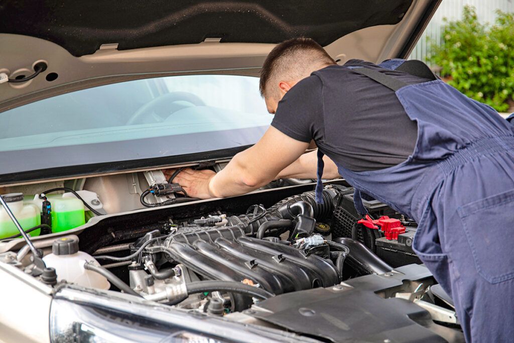 Man leaning over car engine