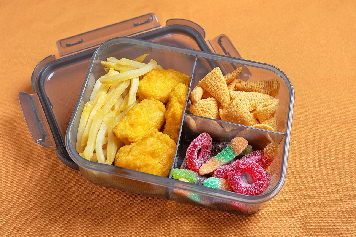 Candy, chicken nuggets, and fries in a container