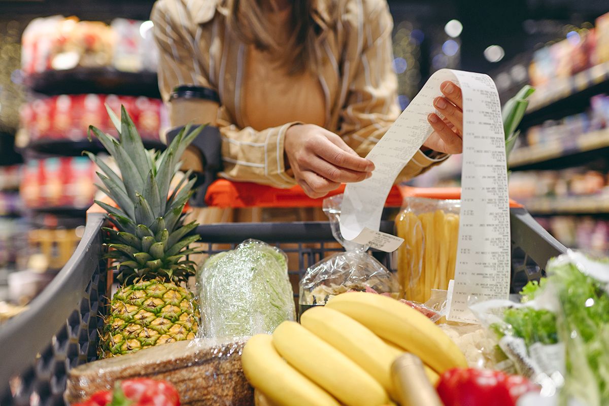 Woman holding long grocery store receipt