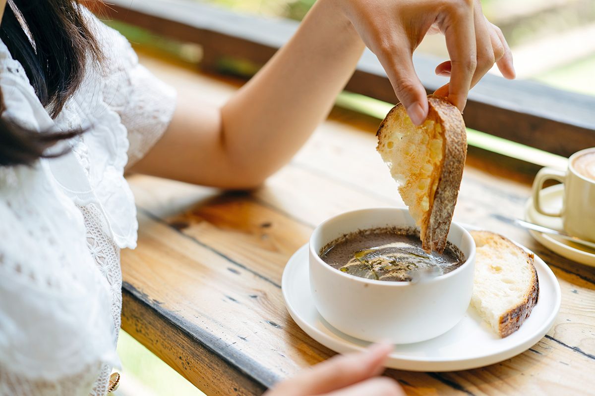 Person dipping bread in soup