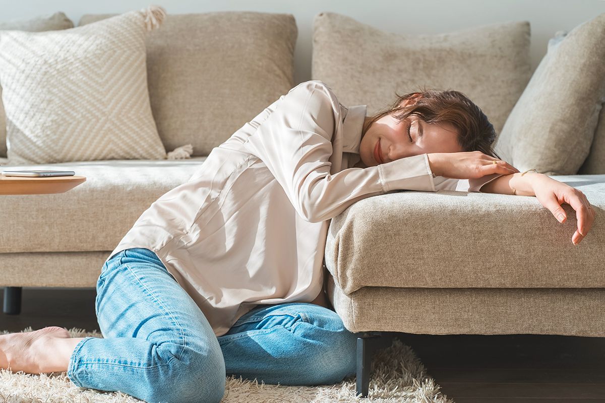 Woman with head down on couch