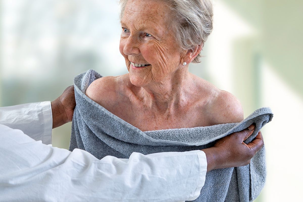 Caregiver toweling off older woman