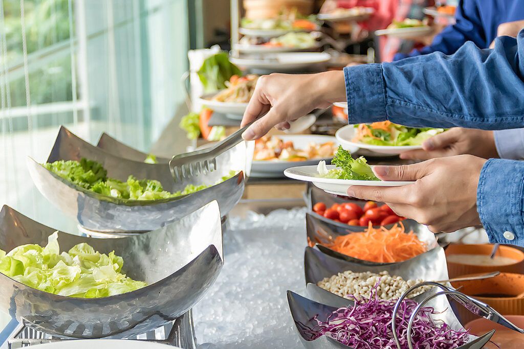 Person taking salad at buffet
