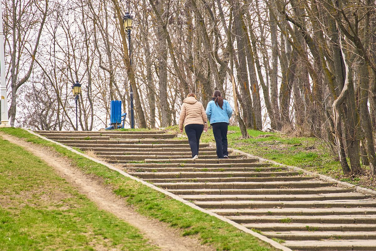 Two women walking up stairs outside
