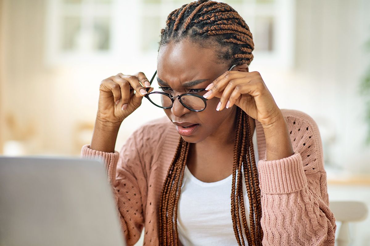 Woman looking at laptop confused