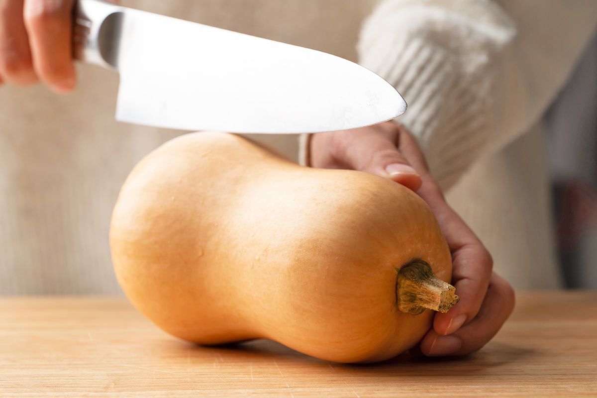 Person cutting butternut squash
