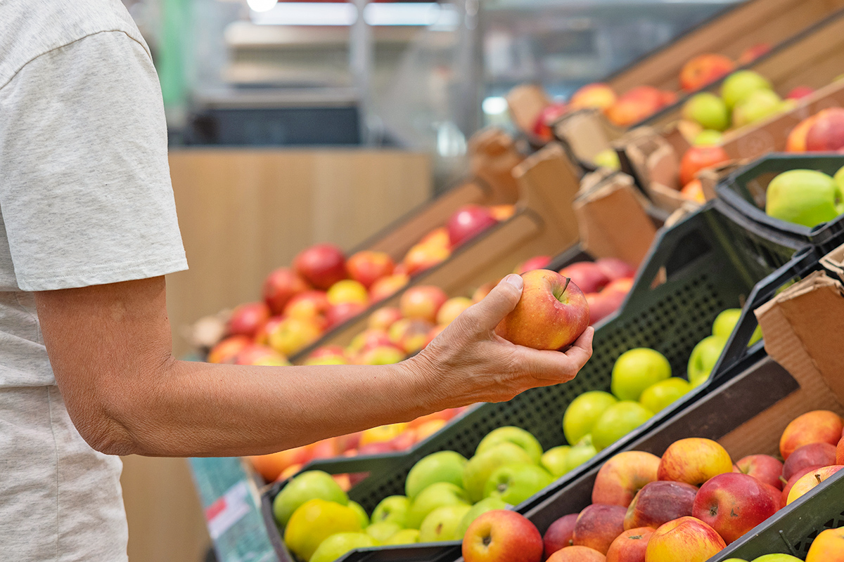 Person holding apple in the grocery store