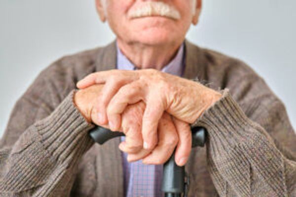 Older man with hands on cane